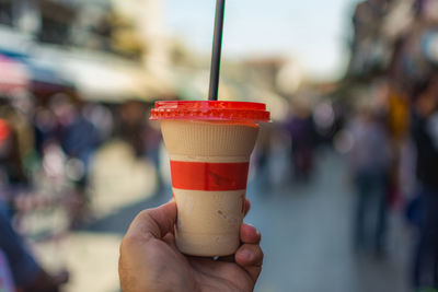 Cropped image of person holding disposable coffee cup