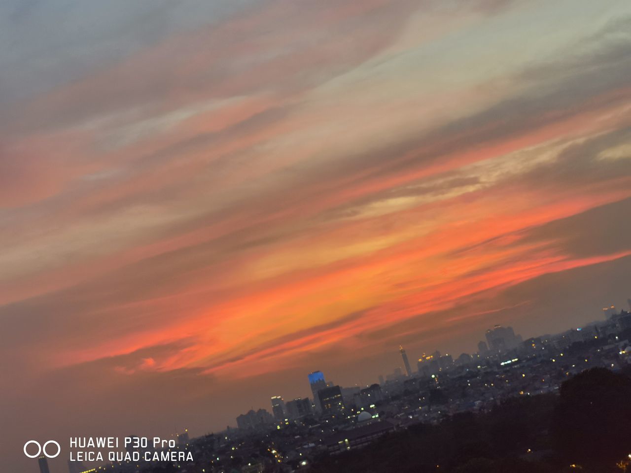 ILLUMINATED BUILDINGS IN CITY AGAINST SKY DURING SUNSET