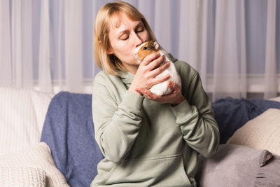 Young woman drinking milk while lying on bed at home