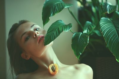 Portrait of topless young woman with fruit on chest