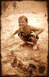 Close-up of girl playing on sand at beach