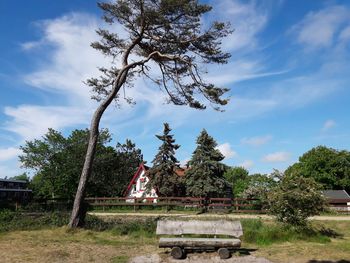 Park bench on field against sky