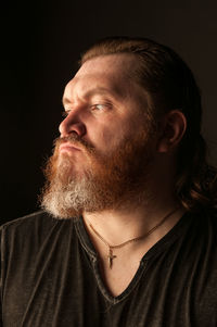 Portrait of man wearing mask against black background