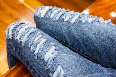 Midsection of woman wearing jeans sitting at home