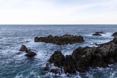 Rock formation in sea against sky