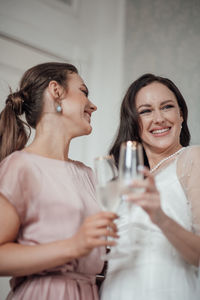 Portrait of a smiling young woman drinking glass