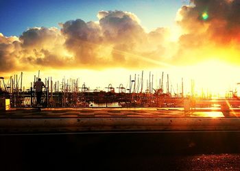 Cranes at harbor during sunset