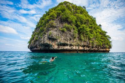 Man surfing in sea against sky