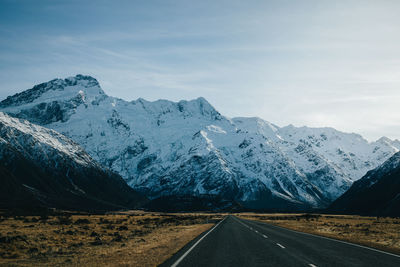 Scenic view of snowcapped mountains against sky with road