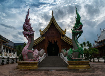 Statue against temple building against sky