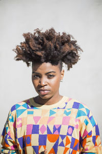 Portrait of young woman standing against white background