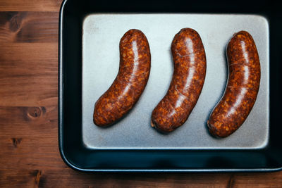 High angle view of roasted sausages in plate on table