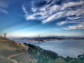 Bridge over sea against cloudy sky