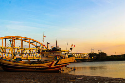 Ship moored at sea against sky during sunset