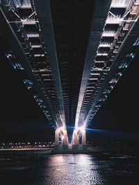 Illuminated bridge over river at night