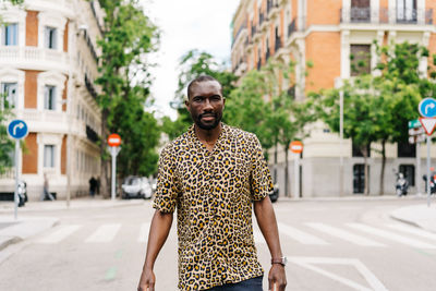 Portrait of man standing on street in city