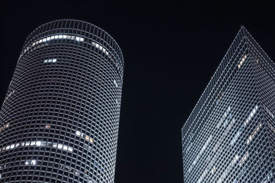 Low angle view of illuminated buildings against clear sky at night