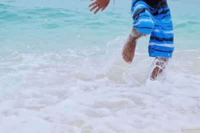 Low section of boy jumping in sea