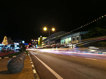 Light trails on road along buildings at night