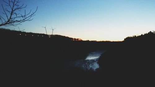 Scenic view of silhouette trees against clear sky during sunset