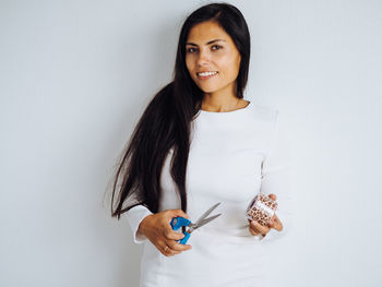 Young beautiful brunette woman with long hair in white dress taking leopard tapes