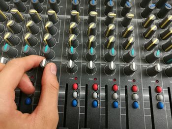 Cropped hands of musician mixing sound with console