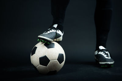 Low section of person standing on soccer ball
