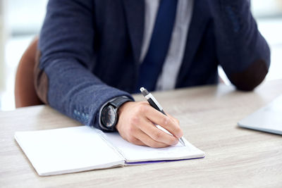 Midsection of businessman working on table