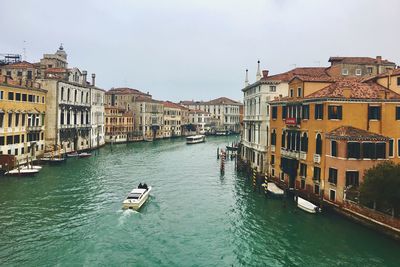 Boats in canal along buildings