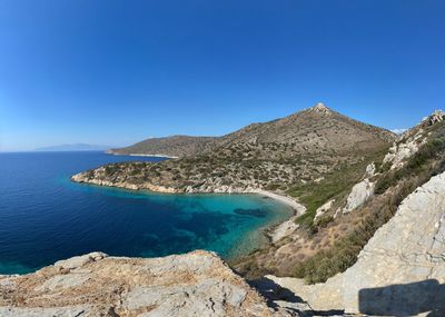 Panoramic view of sea and mountains against clear blue sky