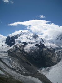 Scenic view of snow covered mountains against blue sky