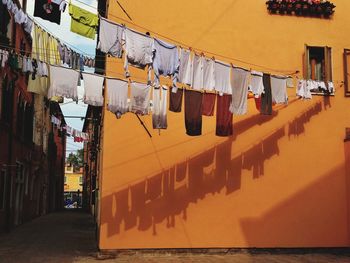 Low angle view of clothes drying on clothesline against buildings