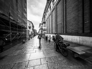 People on street amidst buildings in city