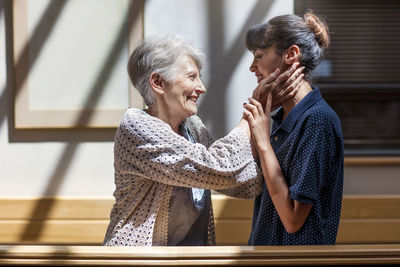 Nurse embracing senior woman in retirement home