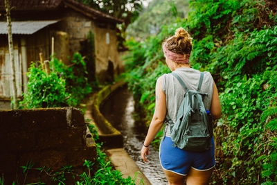 Rear view of woman standing against plants