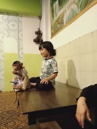 Siblings sitting on floor