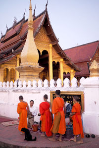 People at temple against clear sky