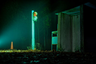 Illuminated light on field by building at night