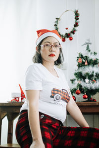 Portrait of young woman sitting on chair at home