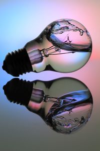 Close-up of electric bulb with water on floor with reflection