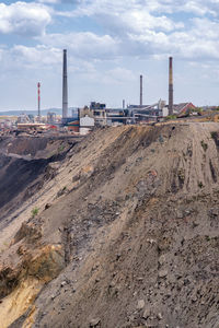 Factory at construction site against sky