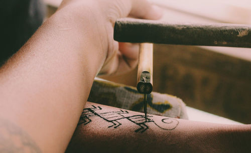 Cropped hand of artist making tattoo