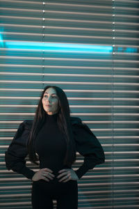 Portrait of young woman looking through window