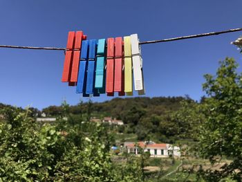 Low angle view of multi colored flags against blue sky