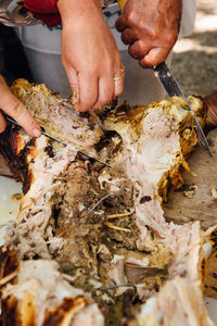 Cropped hands cutting meat