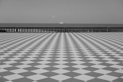 Surface level of chequered floor against clear sky