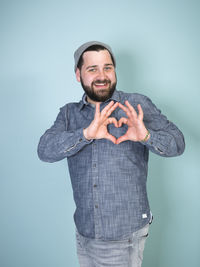 Portrait of smiling man standing against blue background