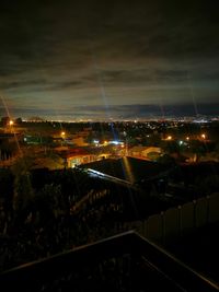 Illuminated city against sky at night