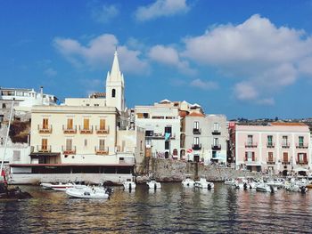 Sailboats in canal against buildings in city