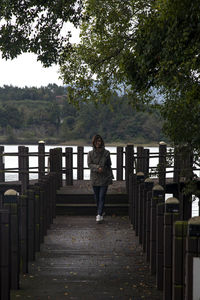 View of a woman on the wooden deck at the seaside